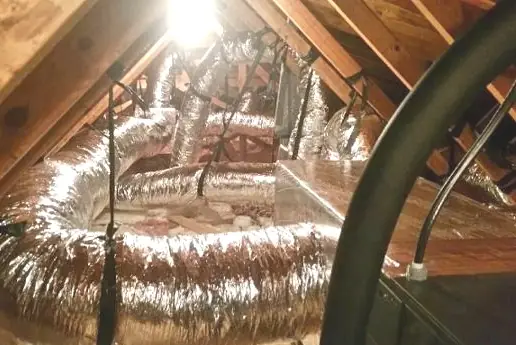 Insulated flexible duct runs feeding a sheet metal plenum in an attic